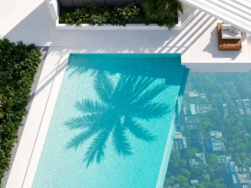 Rooftop infinity pool from above with a palm shadow on the water